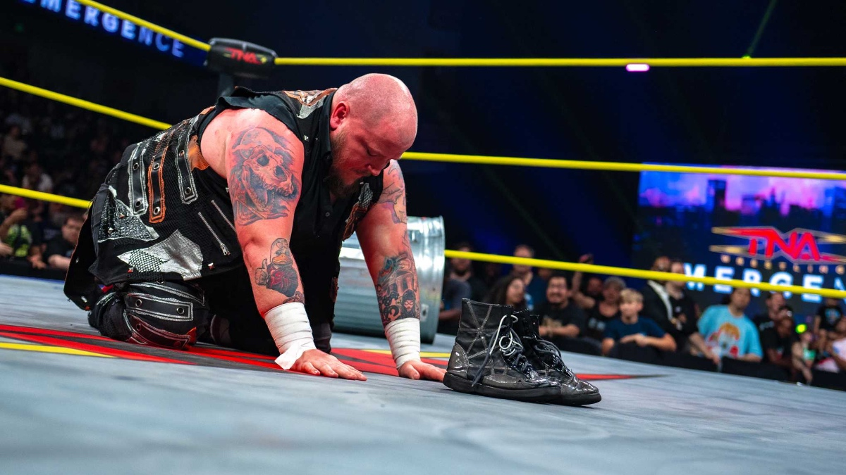 Sami Callihan arrodillado sobre el ring de TNA Wrestling junto a sus botas de lucha durante un momento emotivo frente a los aficionados.