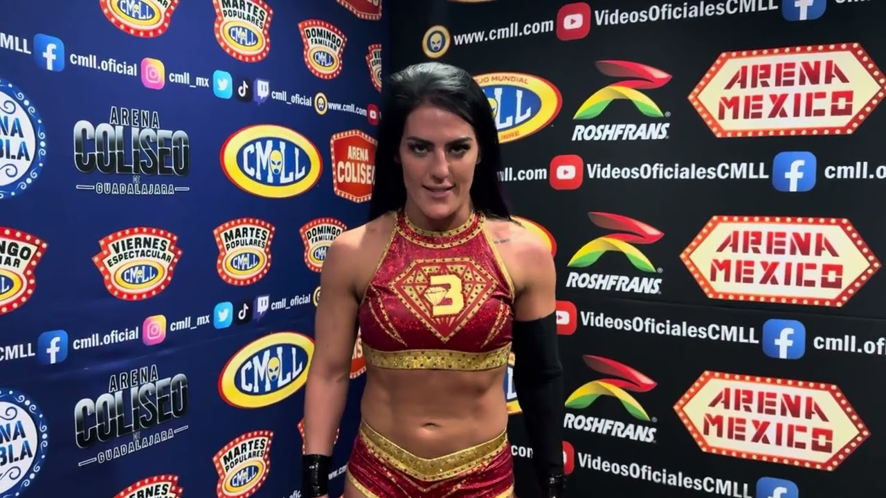 Tessa Blanchard posa frente a un panel con logotipos de CMLL y Arena México durante una entrevista backstage.