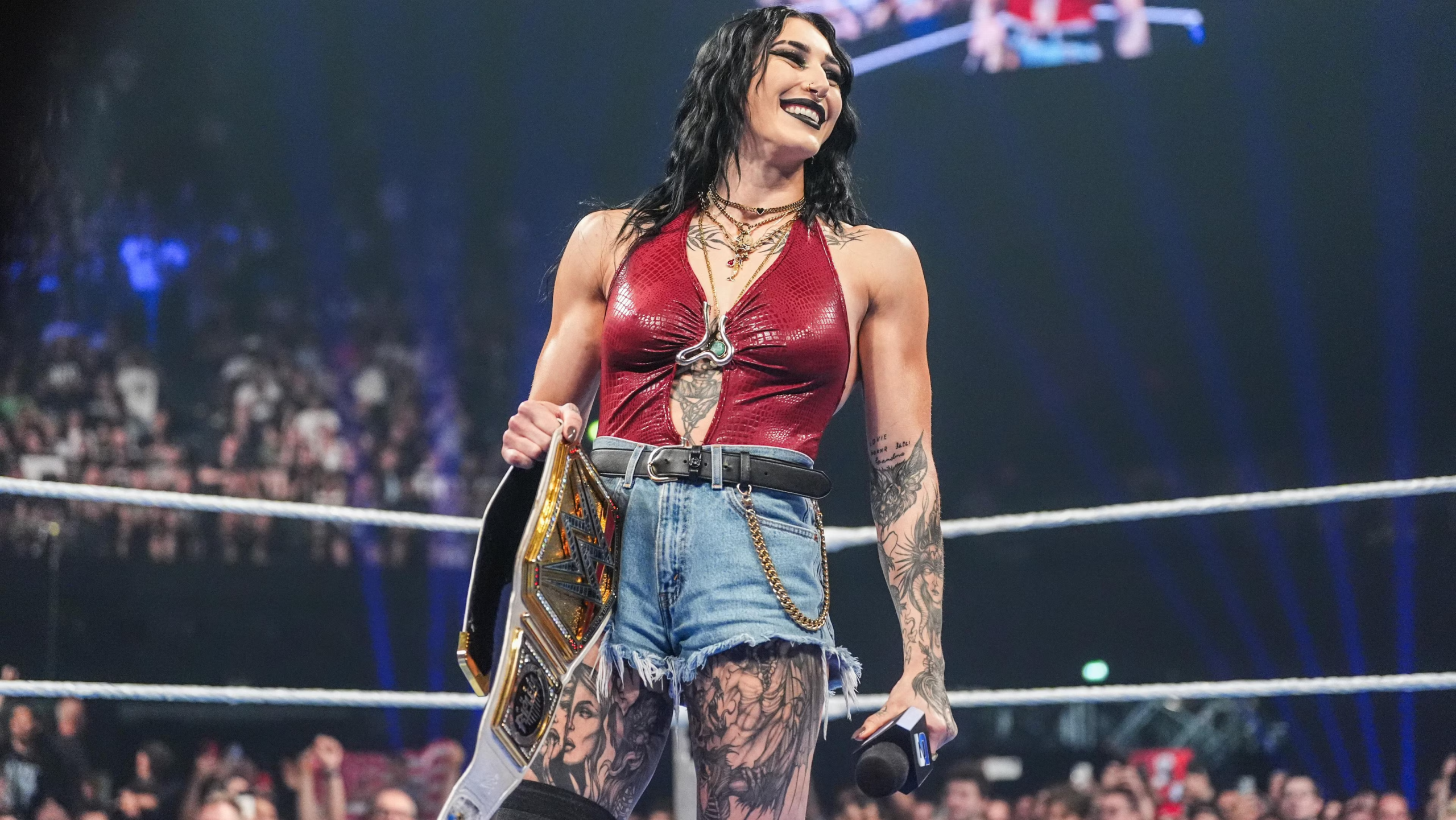 Rhea Ripley sostiene el Campeonato Mundial Femenino de WWE dentro del ring durante un episodio televisado de la empresa.