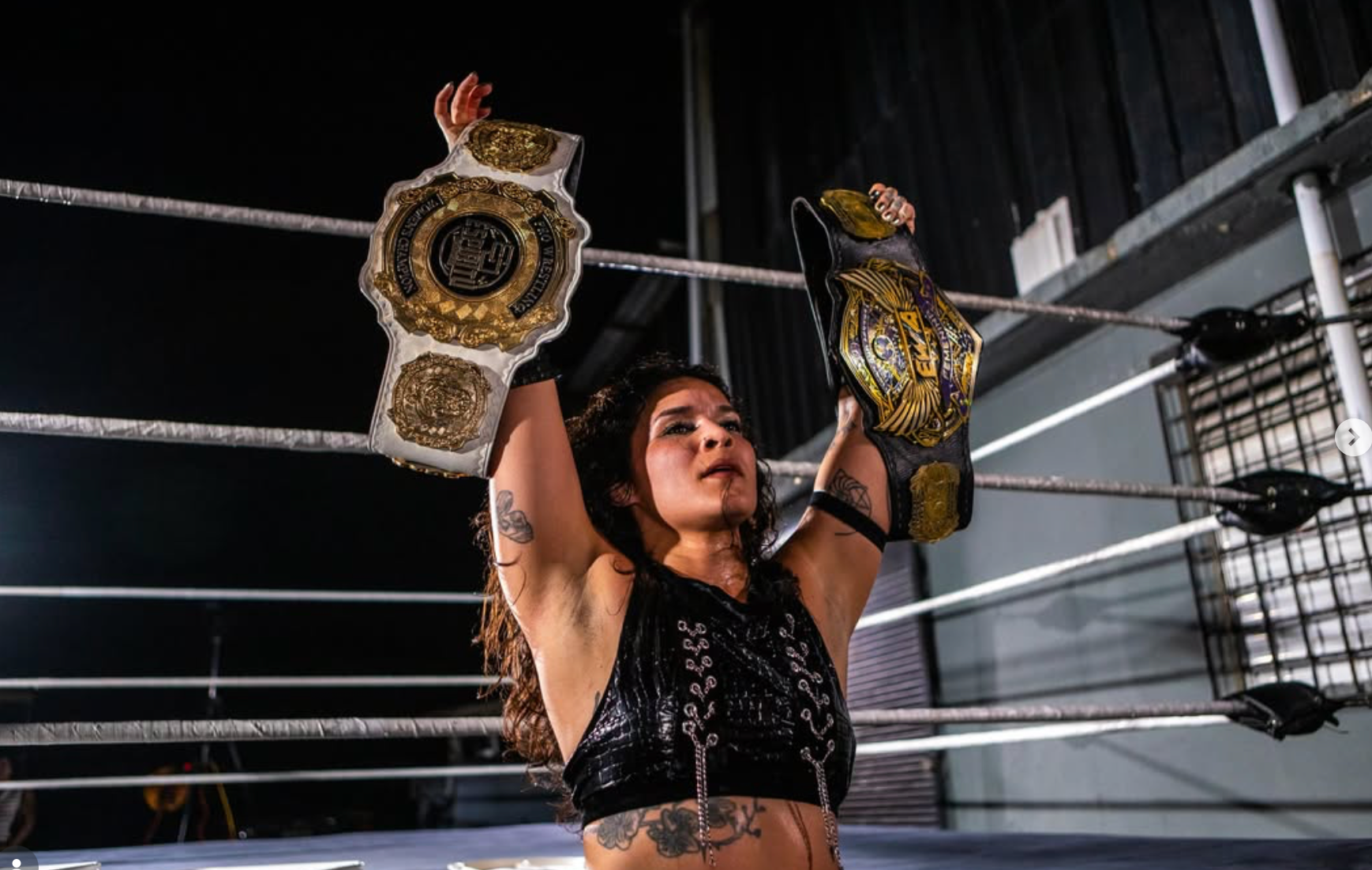 Gema celebra dentro del ring levantando dos campeonatos durante Wrestling Machina en Hato Rey.
