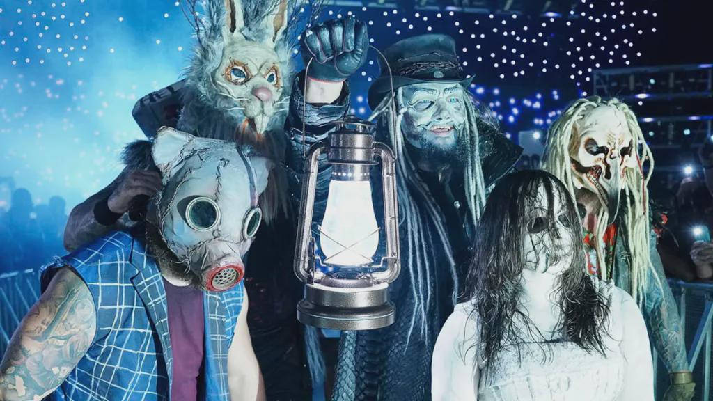 The Wyatt Sicks durante su entrada en WWE con sus máscaras y una linterna encendida.