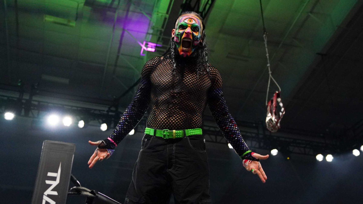 Jeff Hardy con pintura facial multicolor y los brazos extendidos en el ring de TNA Wrestling.