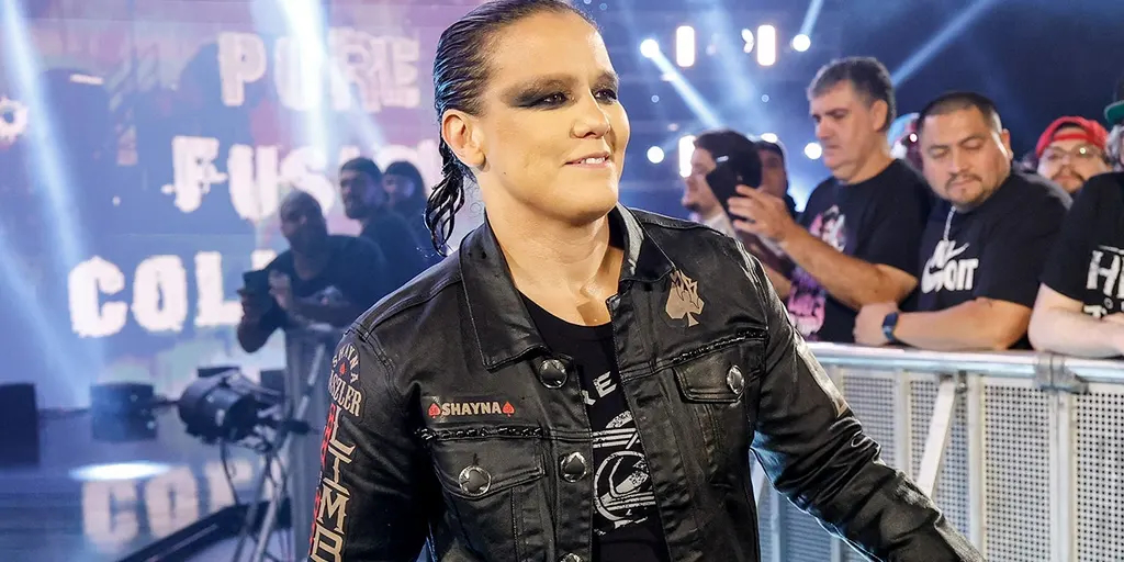 Shayna Baszler camina hacia el ring con una chaqueta negra durante su entrada en WWE.